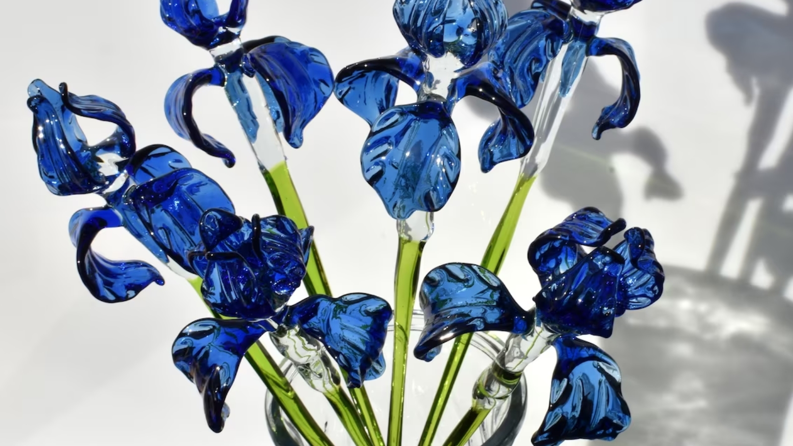collectible statue of an iris flower made of blue glass with an extra-long design