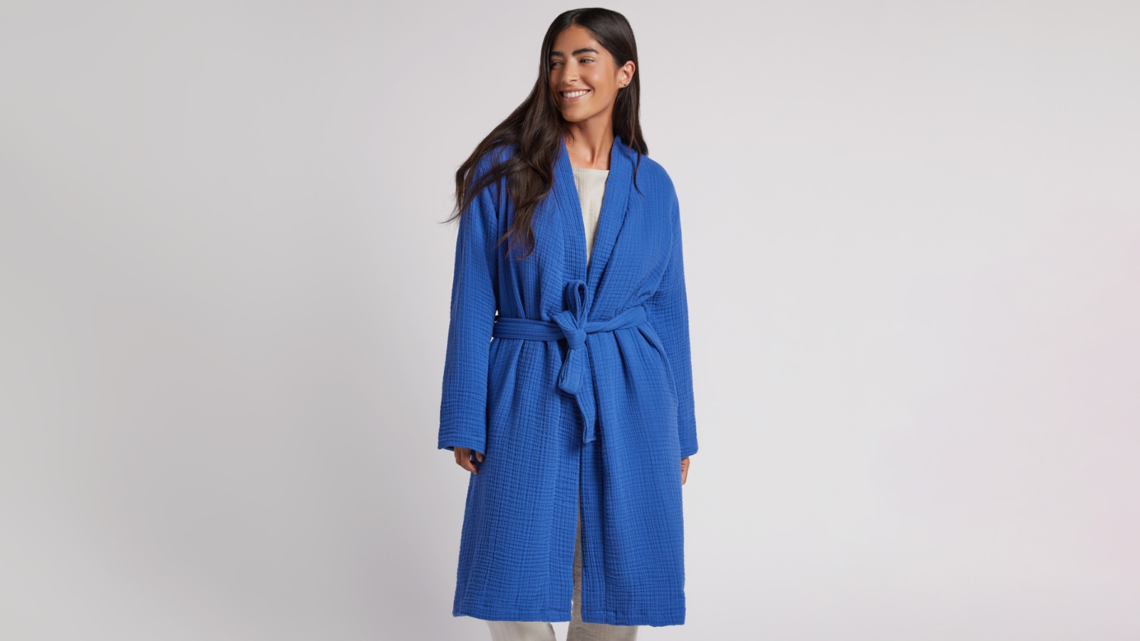 women wearing a cobalt color cotton robe and smiling