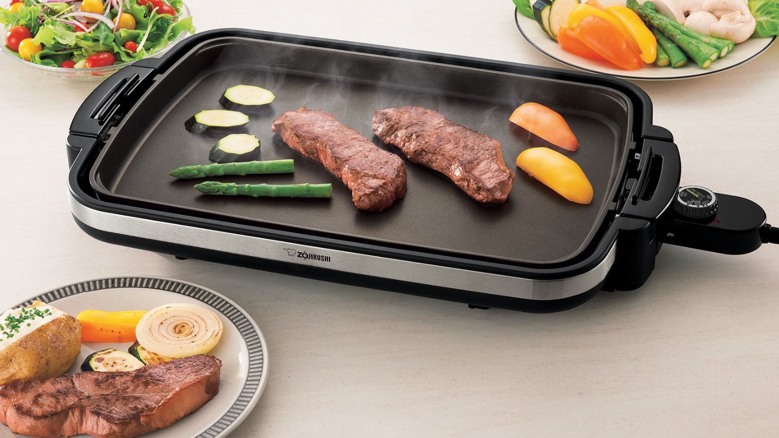 meat being cooked on a electric griddle with large surface